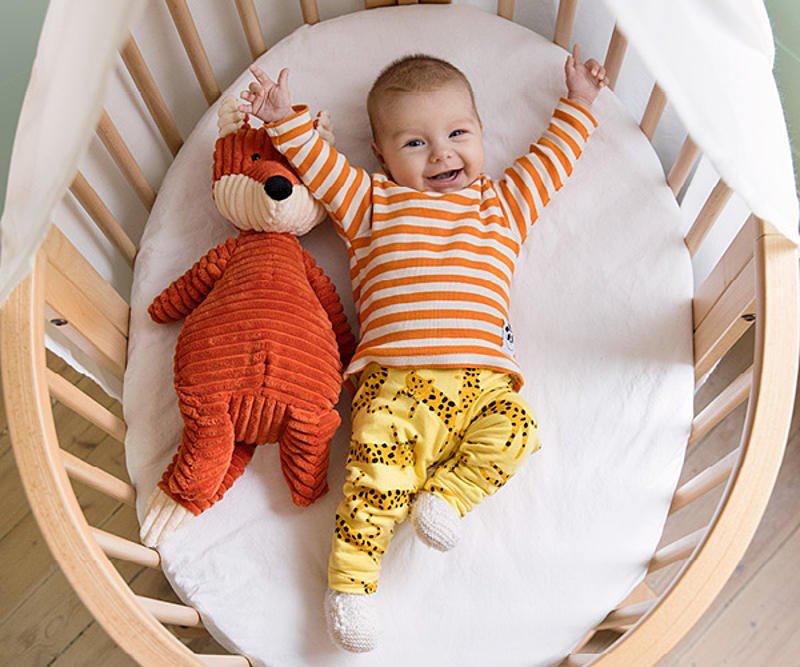 bebé sonriendo en una cuna de bebé Stokke